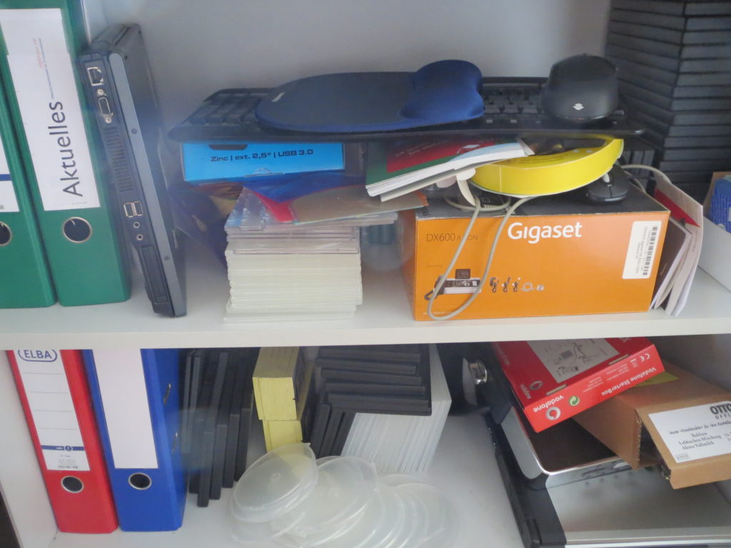 Im Schrank fliegen Geräte und CD-Hüllen, Tastaturen und Kabel durcheinander.