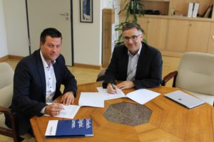 Thomas Jordans und Schulleiter Dr. Uwe Bettscheider unterschreiben den Kooperationsvertrag